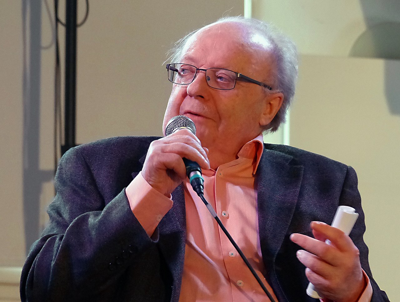 Josef Göhlen spricht während des bumm-Events im Oktober 2015 bei einem Vortrag in ein Mikrofon. Er halt in der rechten Hand ein Mikrofon, in der linken einen Notiz-Zettel.