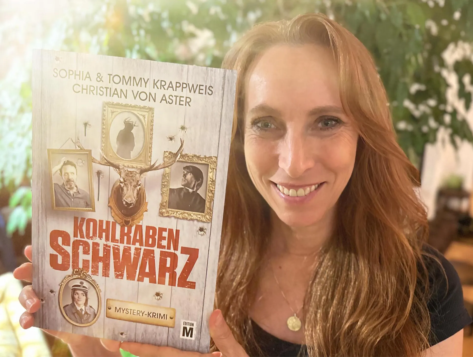Sophia Krappweis hält ein Kohlrabenschwarz-Buch in die Kamera, auf dem ihr Name als Autorin steht.